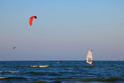 People in sea against sky