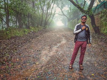 Full length portrait of young man standing in forest