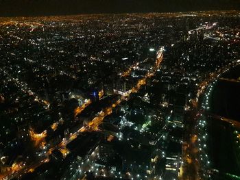 Aerial view of illuminated cityscape against sky at night