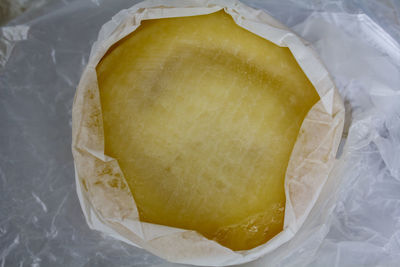 Top view of round cheese wrapped in cheesecloth