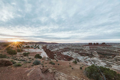 Sun rises over a sea of canyons and red rock cliffs of the maze utah