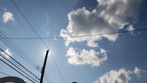 Low angle view of power cables against sky