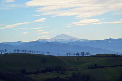 Scenic view of field and mountains against sky