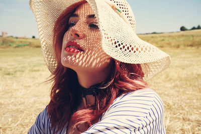 Close-up of woman wearing hat on field