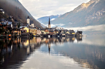 Scenic view of harbor by buildings against sky