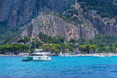 View from the sea of the bay and mondello beach, catamaran anchored in the bay
