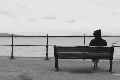 Rear view of people sitting on bench