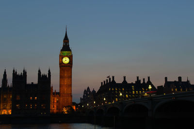 Illuminated clock tower at night