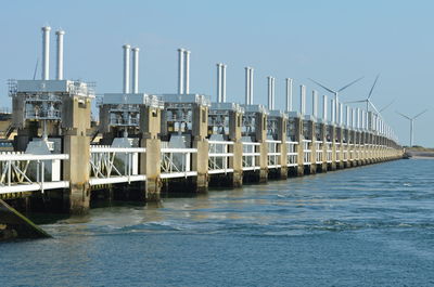 Pier over sea against clear blue sky