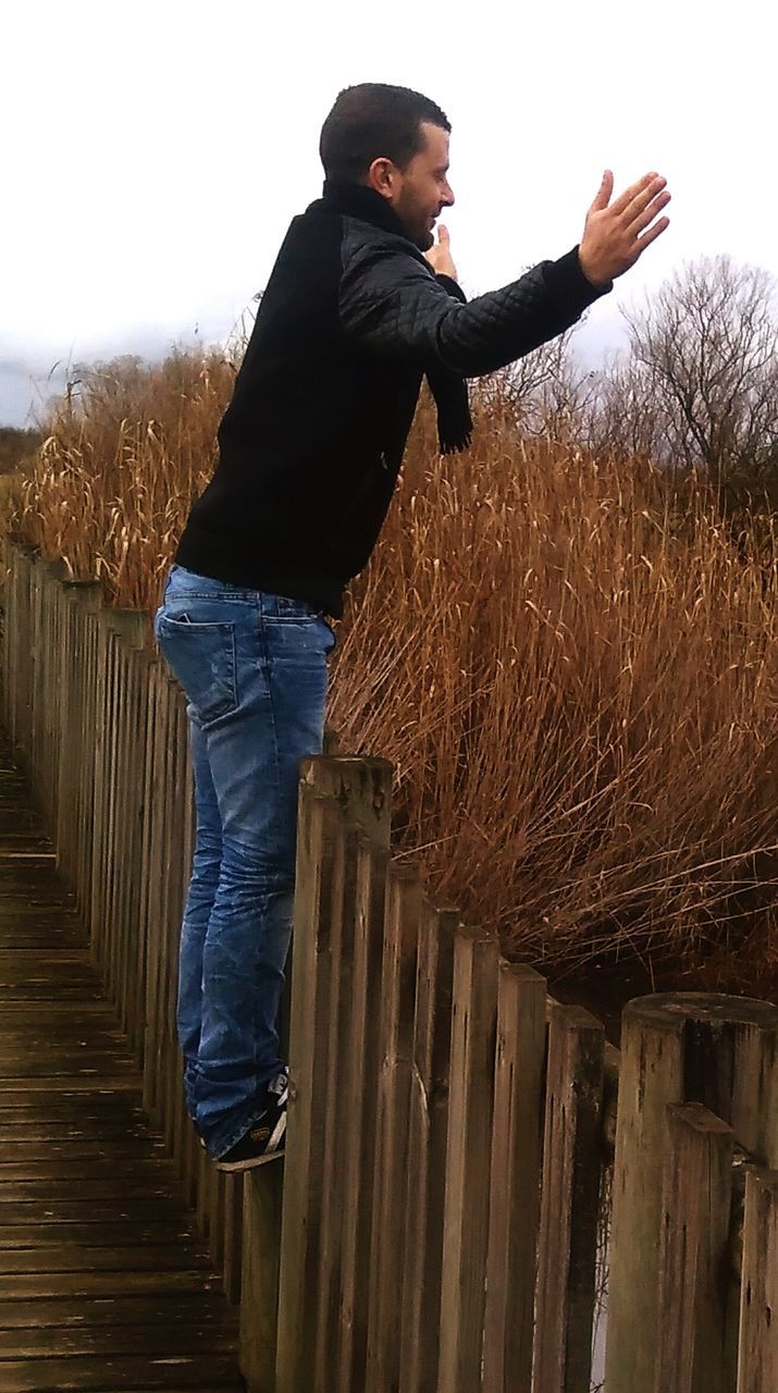 YOUNG MAN STANDING AGAINST THE SKY