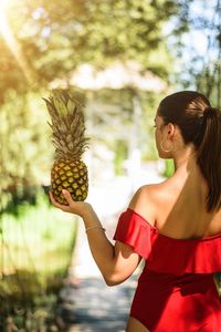 Midsection of woman holding strawberry while standing outdoors