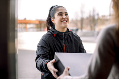 Delivery woman delivering package to customer