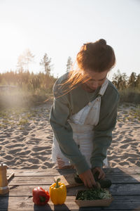 Rear view of young woman sitting by lake