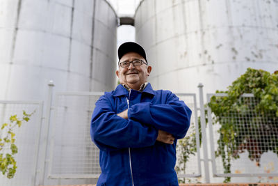 Portrait of smiling man standing against building