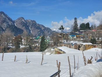 Snow covered land and mountains against sky