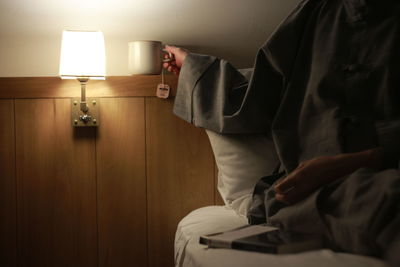 Low section of man relaxing on bed at home