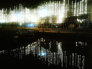 Reflection of illuminated trees in water at night