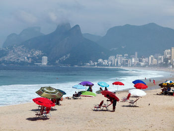 Group of people on beach against sky