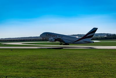 Airplane on airport runway against sky