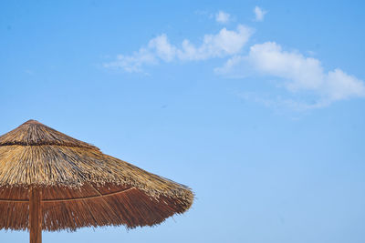 Low angle view of parasol against blue sky