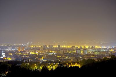 High angle view of illuminated buildings against clear sky at night