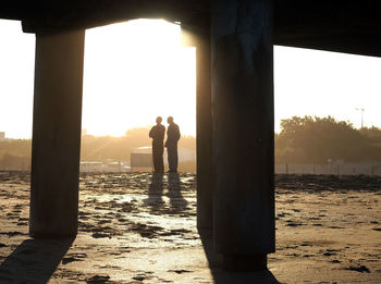 Silhouette people standing against sky during sunset