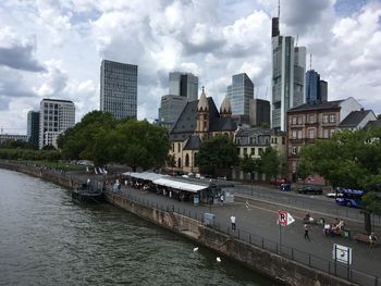 View of city by river against sky