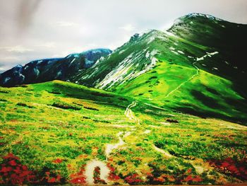 Scenic view of mountain range against cloudy sky