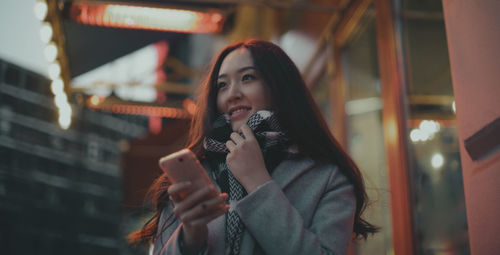 Asian woman with smartphone in the street