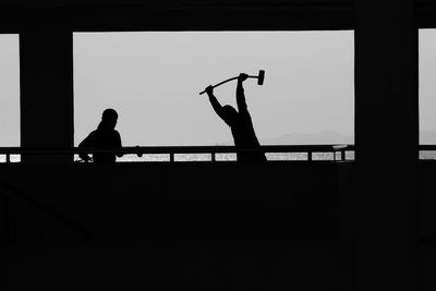 Silhouette man playing against clear sky