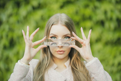 Portrait of beautiful young woman holding glass slab