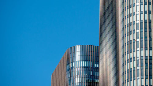 Low angle view of modern building against clear blue sky