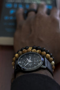 Close-up of person hand on clock