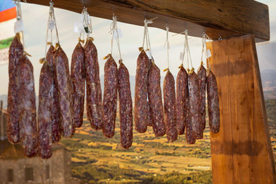 Group of hanging salami inside butcher shop.