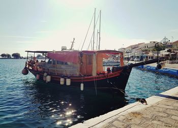 Boats moored at harbor against clear sky