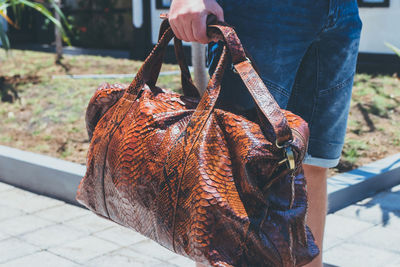 Man with python skin travel bag