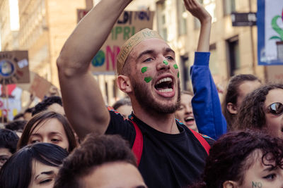 Portrait of young man with arms raised