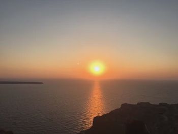 Sun shining through clouds over sea