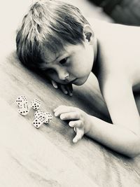 High angle view of boy playing with dices on table