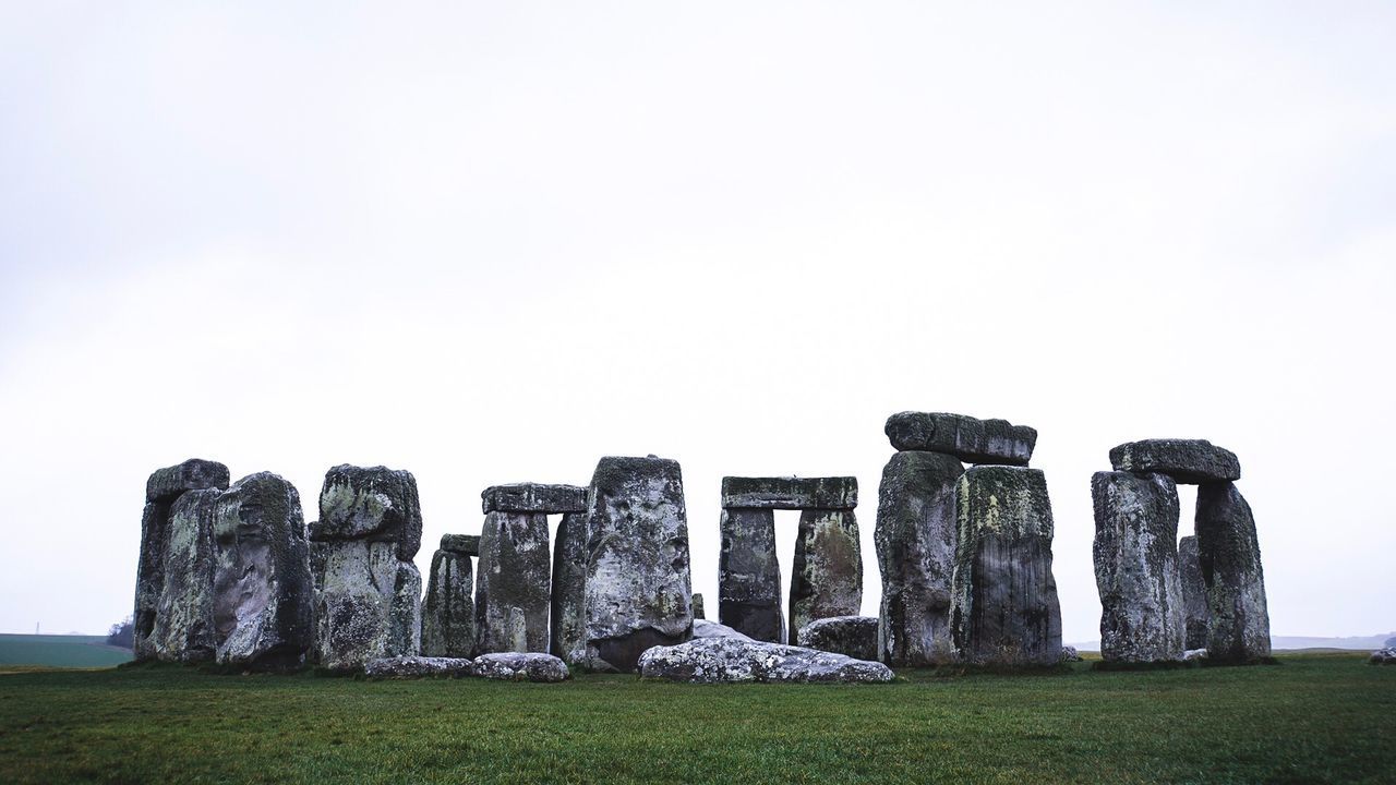 ROCKS ON FIELD AGAINST SKY