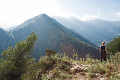 Rear view of woman standing against mountains