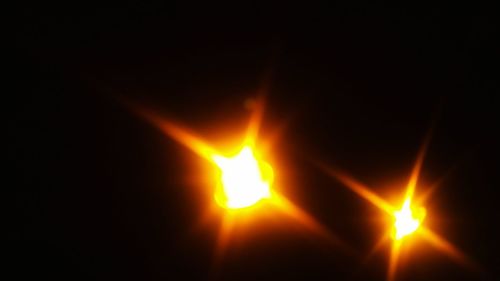 Close-up of lit candle against sky during sunset