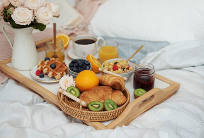 Romantic breakfast with coffee, waffles, orange juice and rose flowers.