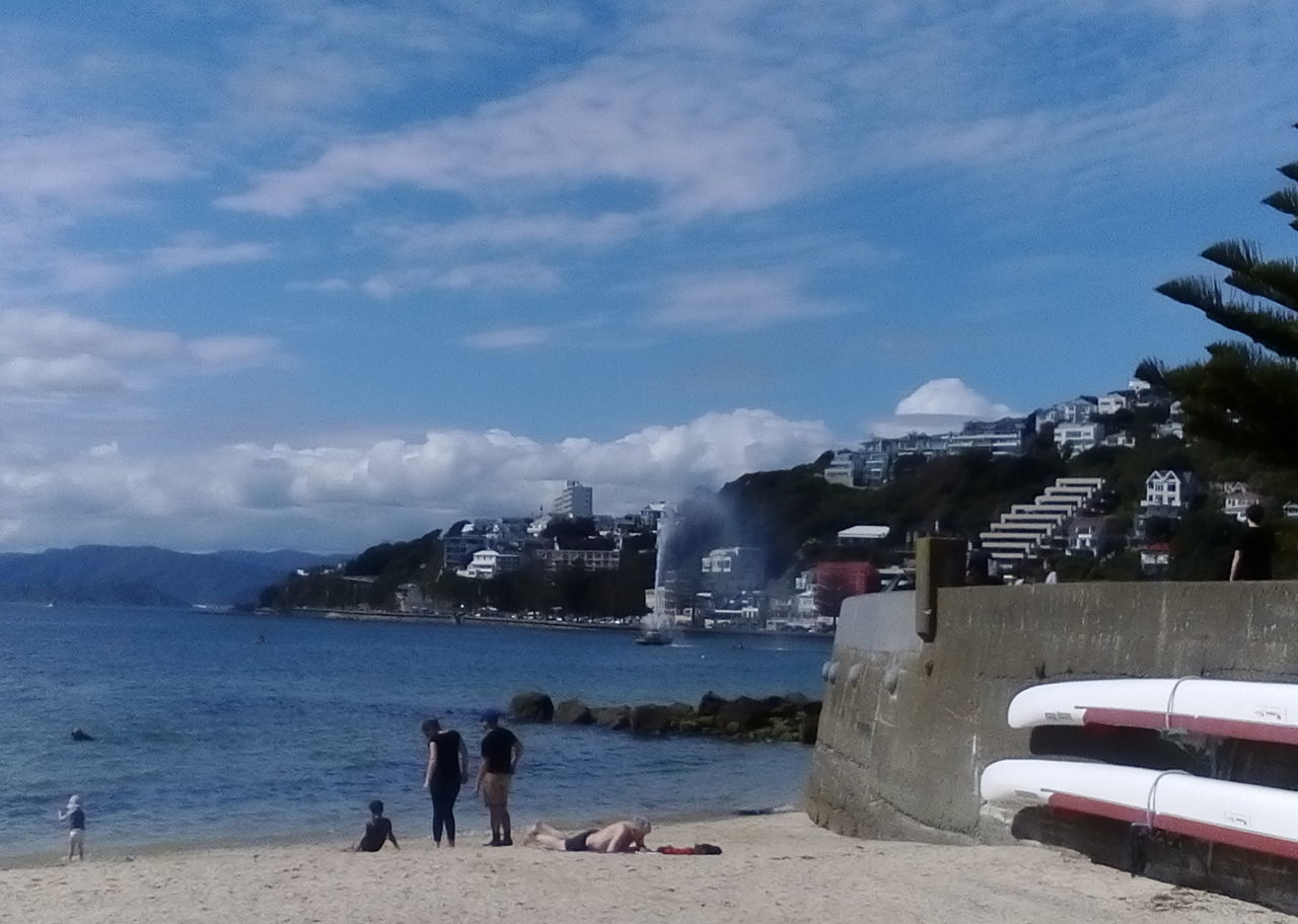 PEOPLE AT BEACH AGAINST SKY