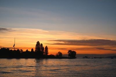 Scenic view of lake against orange sky