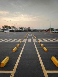 Surface level of road against sky during sunset