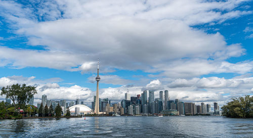 View of river and buildings against cloudy sky