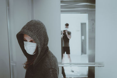 Young woman standing against wall