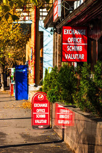 Information sign by trees in city