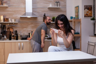 Young woman using mobile phone while sitting in cafe